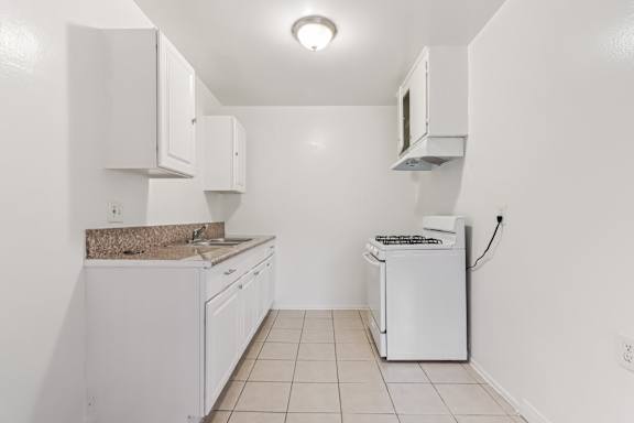 A white kitchen with a washing machine and a microwave.