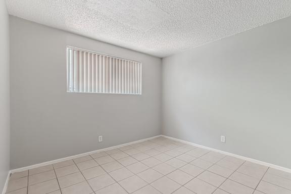 A room with a window and tiled floor.