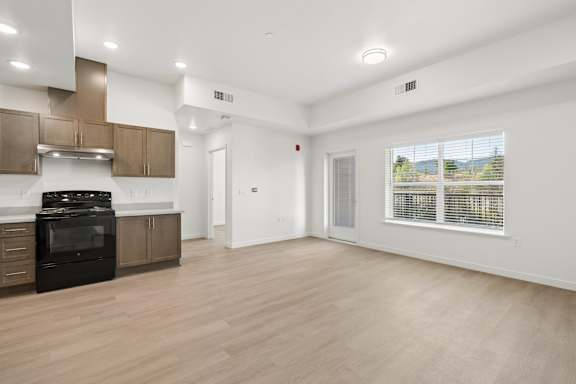 A spacious kitchen with wooden floors and modern appliances.