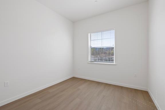 A room with a window and wooden flooring.