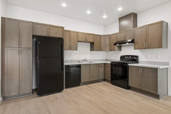 A kitchen with wooden cabinets and black appliances.
