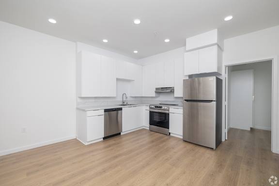 A modern kitchen with white cabinets and stainless steel appliances.