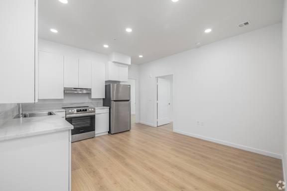 A kitchen with white cabinets and stainless steel appliances.