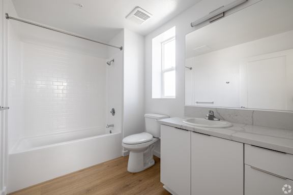 A white bathroom with a toilet, sink, and bathtub.