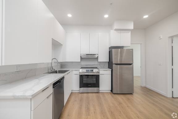 A modern kitchen with white cabinets and stainless steel appliances.