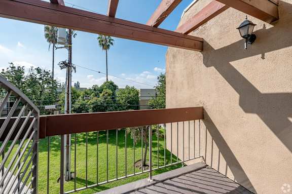 A balcony with a metal railing and a lamp post at Oak Park Apartments, Monrovia, 91016