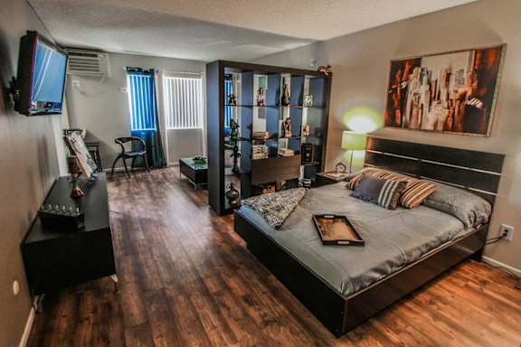 a bedroom with a large bed and a tv in a studio apartment&#xA0;at The Marquee Apartments, North Hollywood 91605