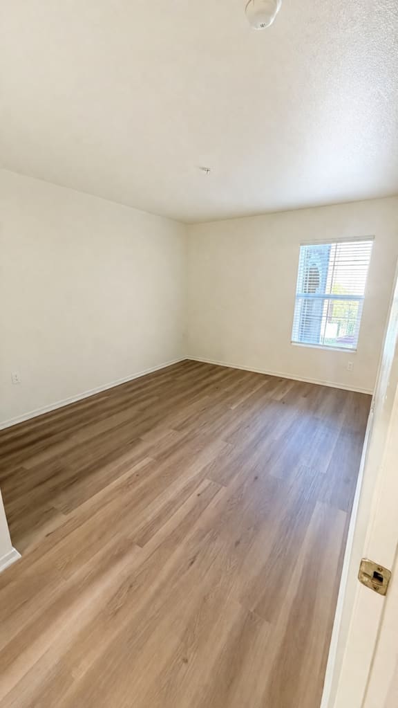 A room with wooden flooring and a window.