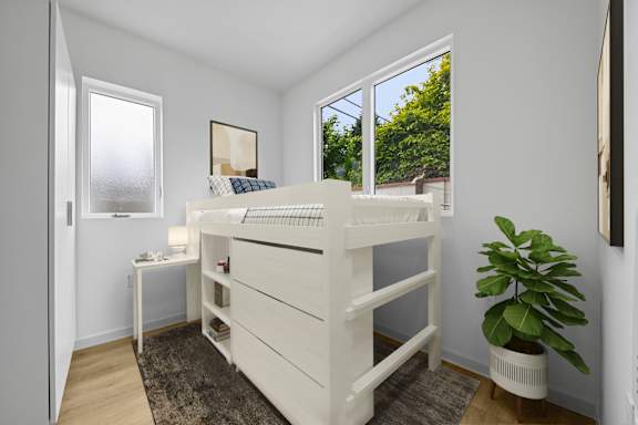 A white bunk bed in a room with a window.