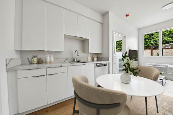 A modern kitchen with a dining table and chairs.
