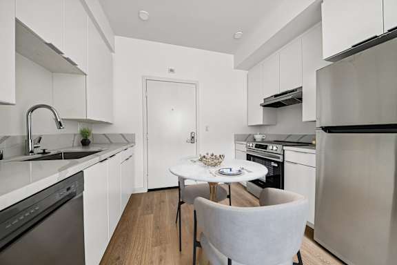 A modern kitchen with a table and chairs.