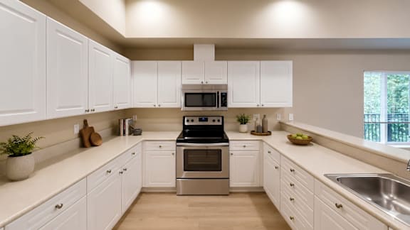 A kitchen with white cabinets and a stainless steel stove.