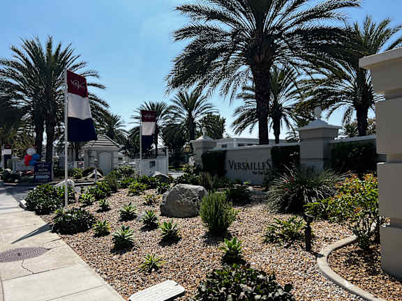 A garden with a Versailles sign in the background.