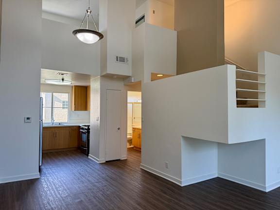 A modern open concept living space with a kitchen, dining area, and stairs.