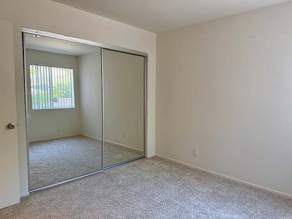 A room with a white door and a carpeted floor.