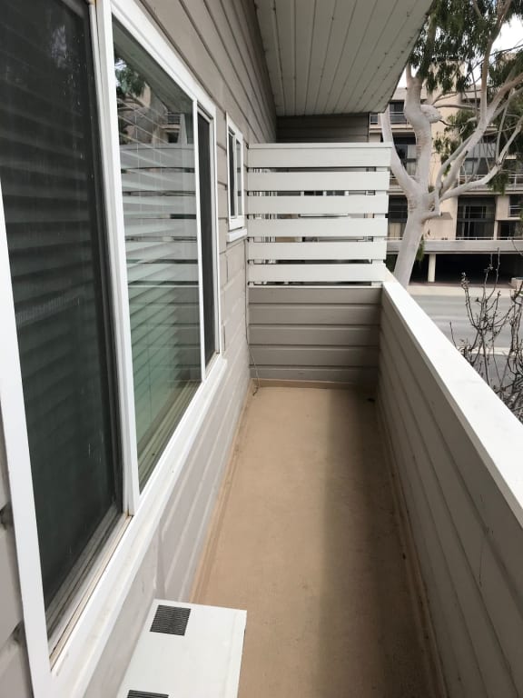 a covered porch with white walls and a large window