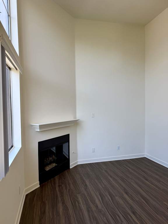 A room with a fireplace and wood flooring.