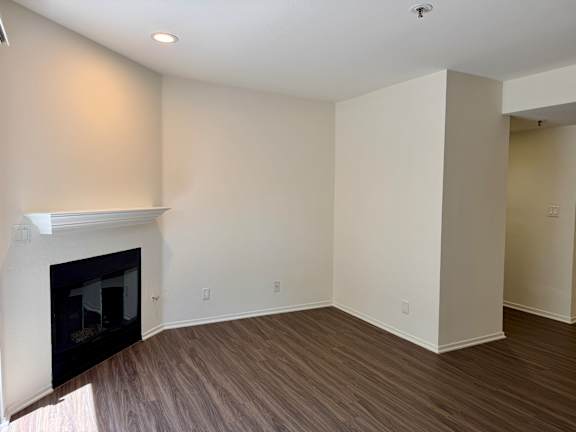 A room with a fireplace and wood flooring.