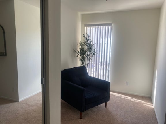 a living room with a black chair and a window