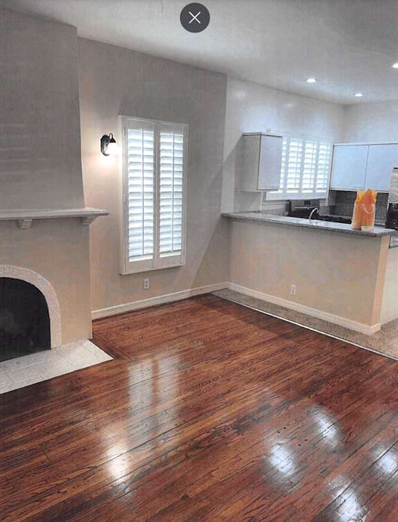 A room with a fireplace and wooden floors.