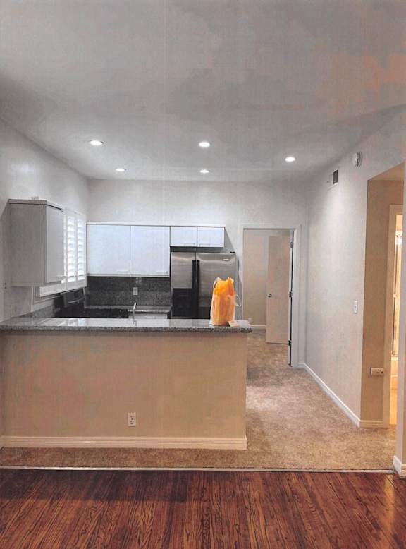 A kitchen with a wooden floor and a counter.