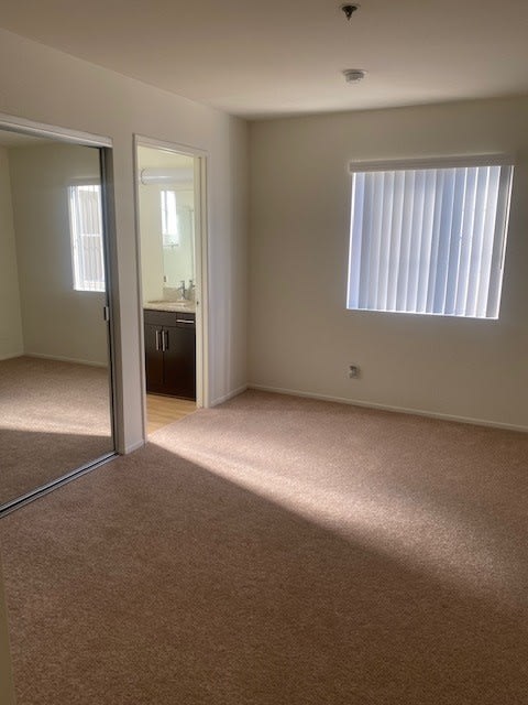 an empty room with a window and a mirror