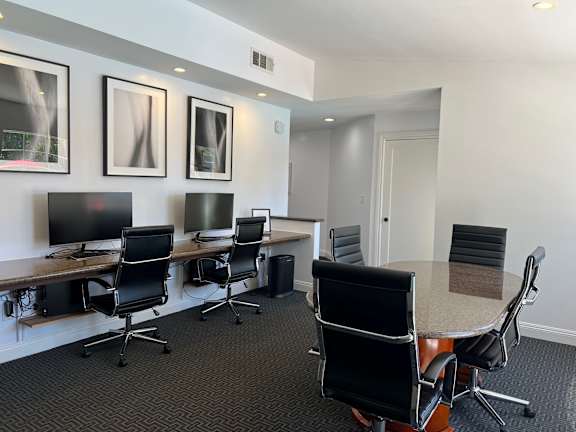A conference room with a long table and chairs.
