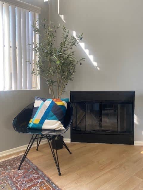 A black fireplace with a blue and yellow blanket on a black chair.