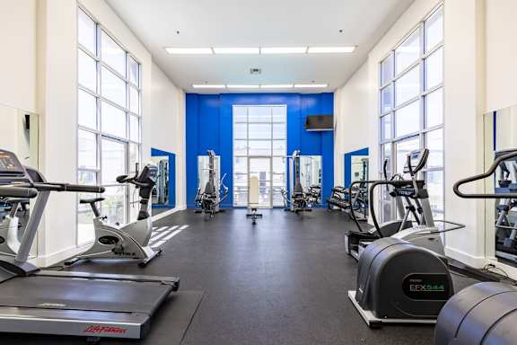 A gym with treadmills, elliptical machines, and other exercise equipment.