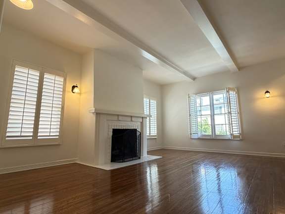A room with a fireplace and wooden floors.