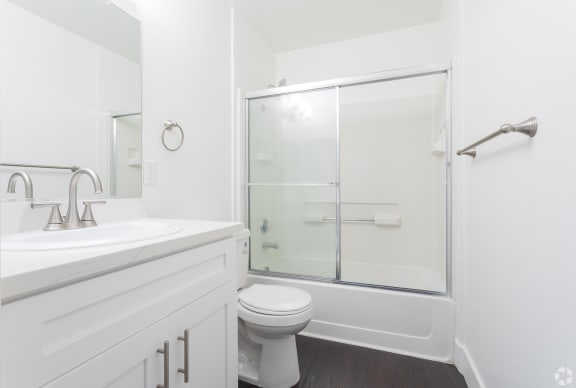 a bathroom with a shower and a sink and a toilet