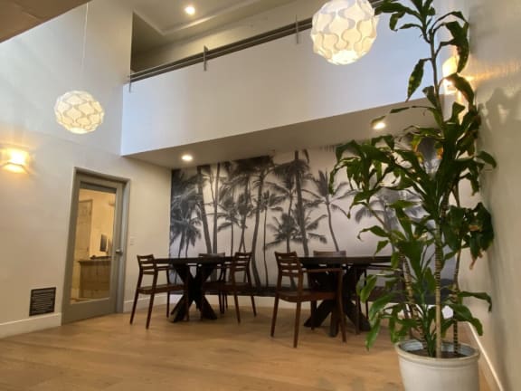 a dining room with a table and a potted plant