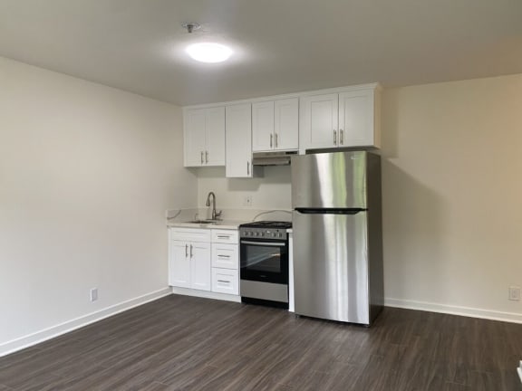 a kitchen with a stainless steel refrigerator and white cabinets