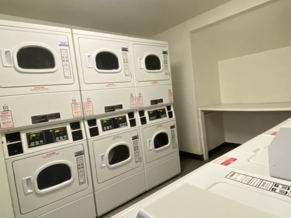 a row of washers and dryers in a laundry room
