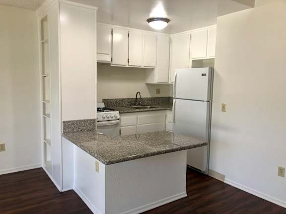 a kitchen with white cabinets and a black stove top