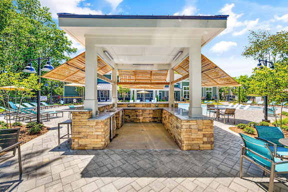 a covered patio with a bar and chairs
