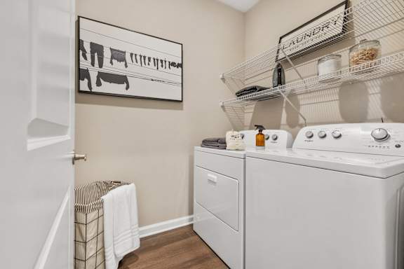 a laundry room with a washer and dryer and a door to a bathroom