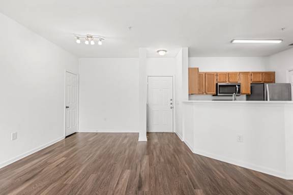 A kitchen area with wooden floors and white walls.