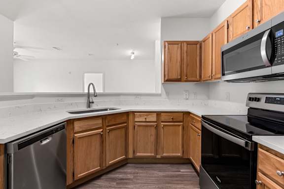 A kitchen with wooden cabinets and a black stove top oven.