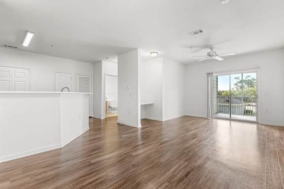 A spacious room with wooden floors and white walls.