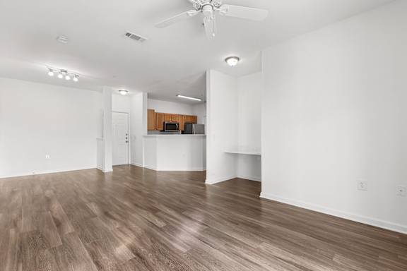 A room with a ceiling fan and wooden flooring.