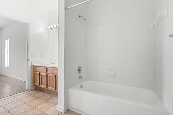 A white bathroom with a tub and a sink.