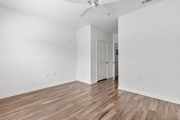 A room with a wooden floor and a ceiling fan.