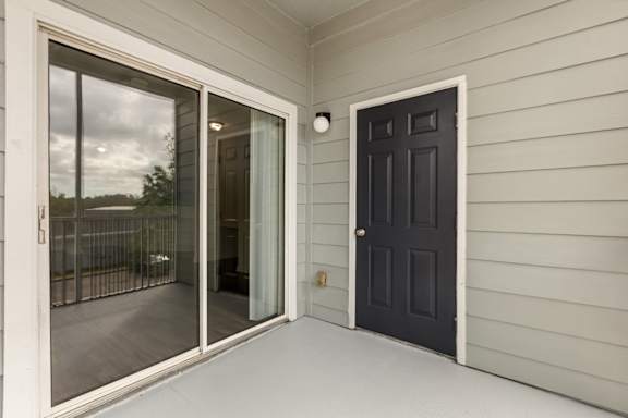 A black door is on the right side of a white wall.
