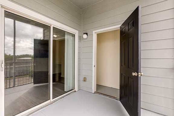 A black door is open to a room with a white wall.