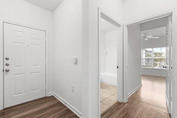 A white door with a silver handle is on the left side of the image.