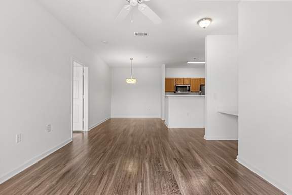 A room with wooden flooring and a ceiling fan.