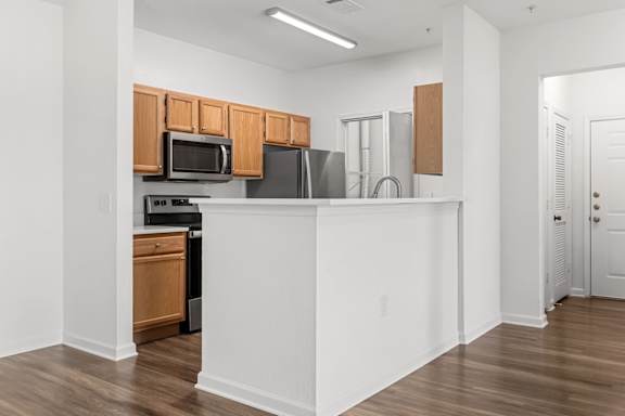 A kitchen with wooden cabinets and a white island.