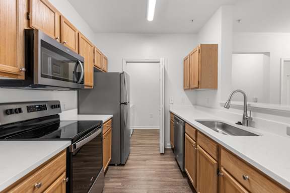 A kitchen with wooden cabinets and black countertops.