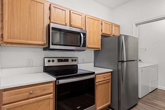 A kitchen with a stove, oven, microwave, and refrigerator.
